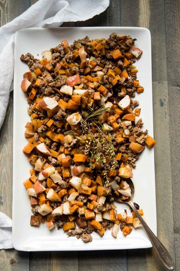 overhead angle of sweet potato hash on a serving platter with an antique spoon