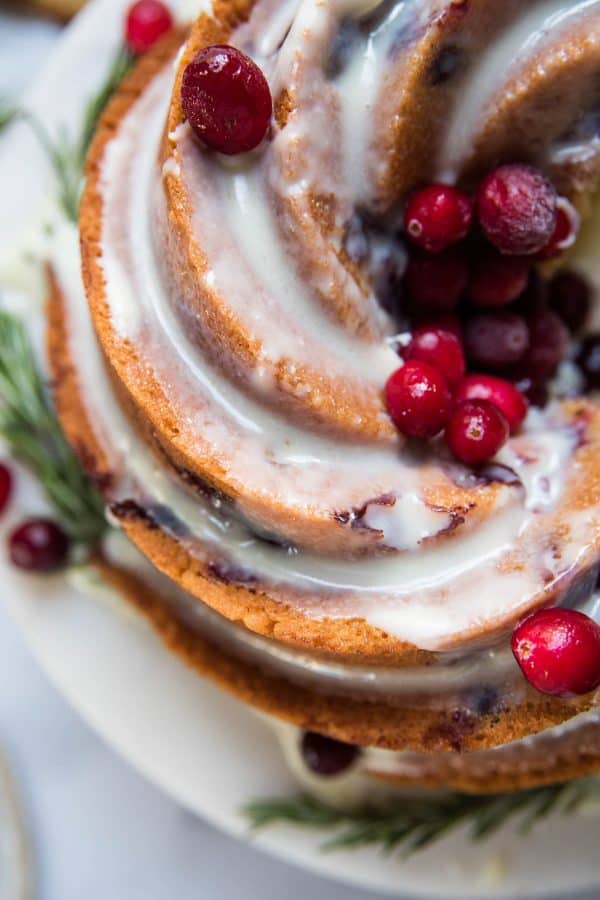 close up of cranberry bundt cake with white chocolate drizzled over
