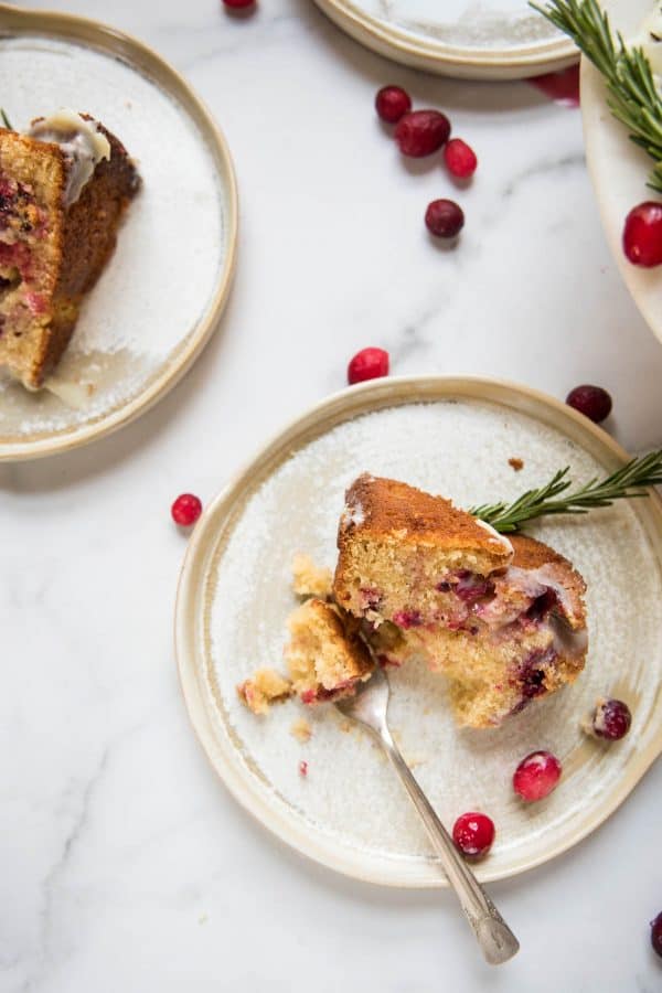 a slice of cranberry cake on a plate with a forkful