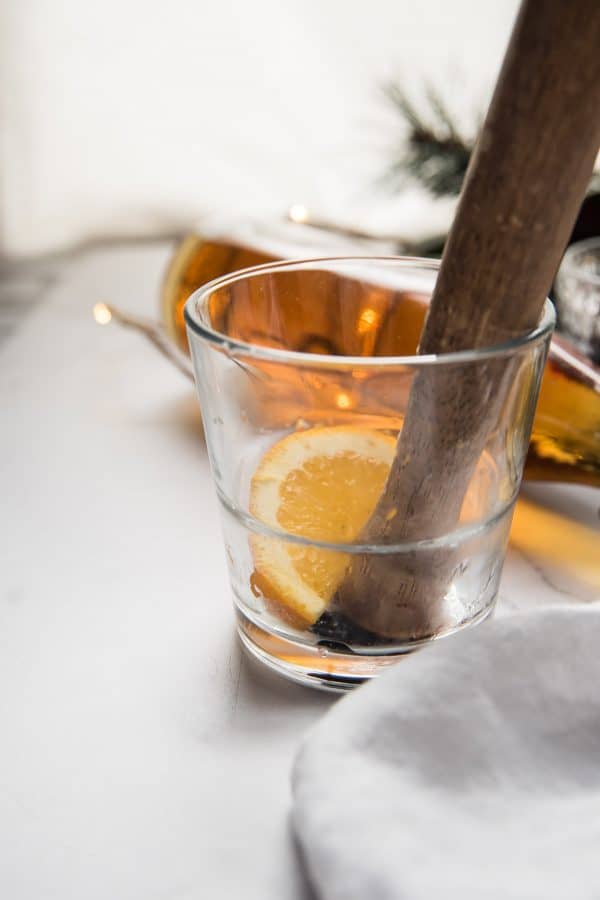 muddling orange and cherry in a glass