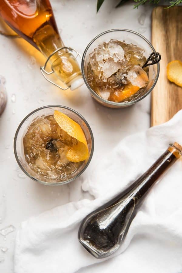 holiday old fashioned cocktails with container of gingerbread syrup