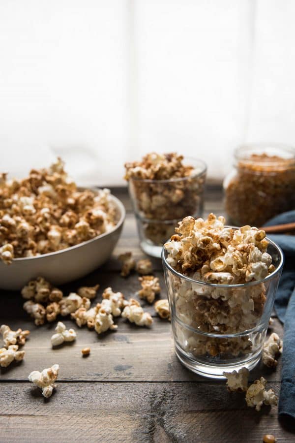 side angle of kettle corn style popcorn in glasses and bowl