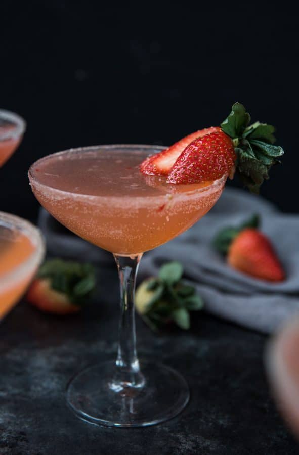 strawberry martini garnished with a fresh strawberry and sugar rim