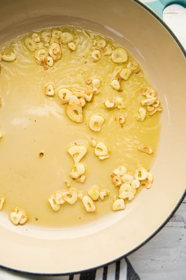 thinly sliced garlic browning in hot olive oil