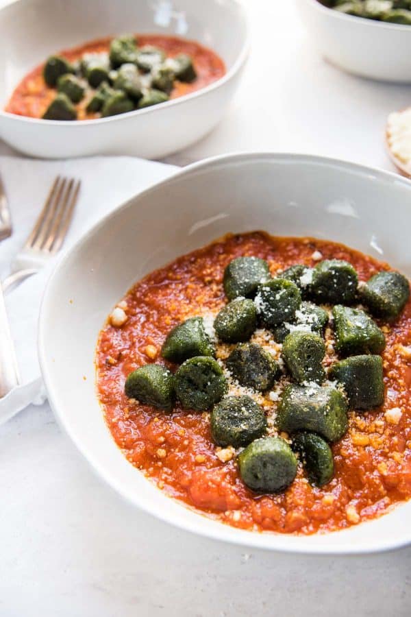 green kale gnocchi sitting on top of arrabbiata sauce