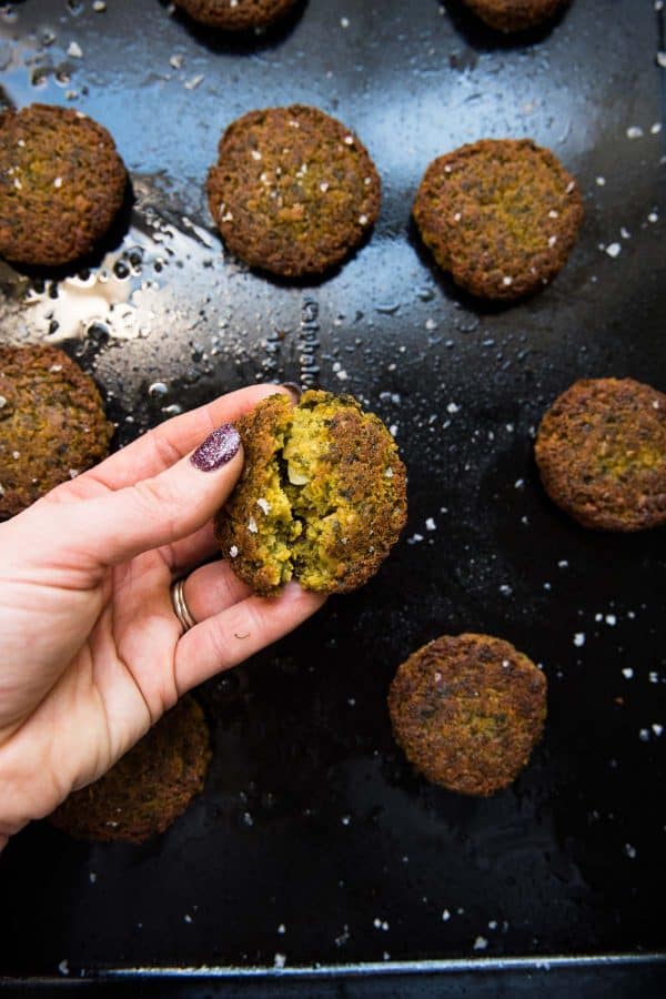 oven baked falafel patties on a black sheet tray