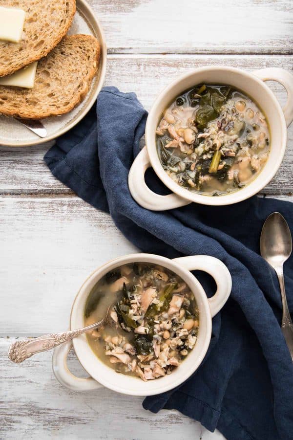 two bowls of soup with buttered bread