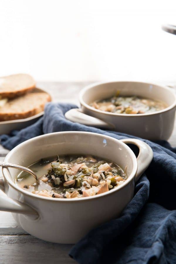 chicken and wild rice soup in bowls with spoon sticking out of them