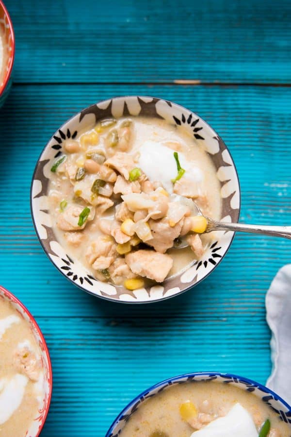 spoon scooping white chicken chili out of a bowl