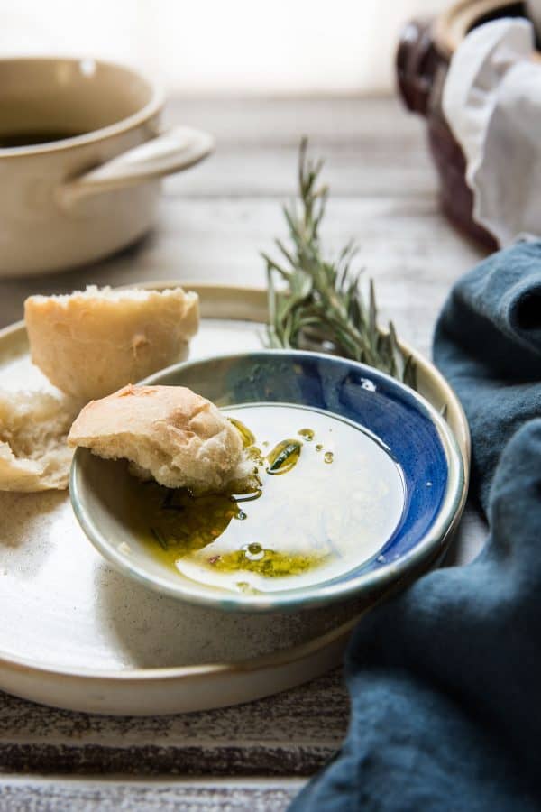 side angle of roll dipping into blue plate with dipping oil