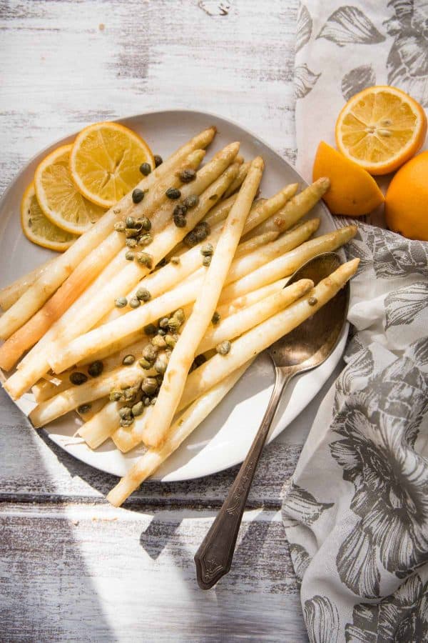 sunlight on a plate of white asparagus piccata