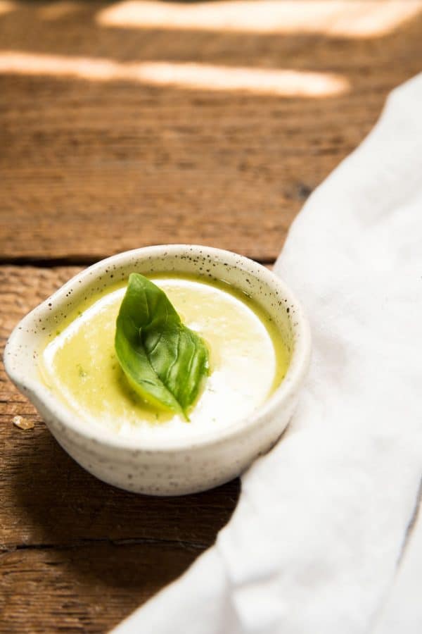 lemon basil dressing in a ramekin with a basil leaf