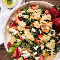 large platter with sourdough panzanella and a small ramekin of dressing