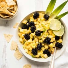 overhead of blackberry pineapple salsa in a serving bowl with chips