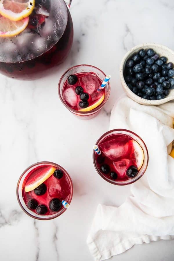 overhead photo of blueberry lemonade in glasses with lemon slices