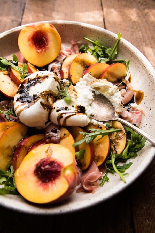 close up of a spoon cutting through burrata cheese