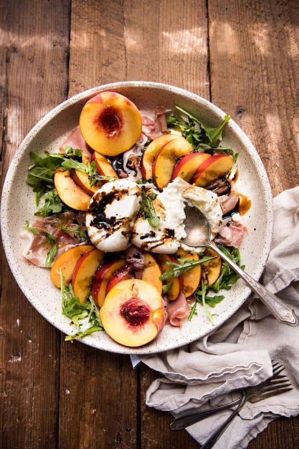 overhead photo of peach burrata salad in a large platter