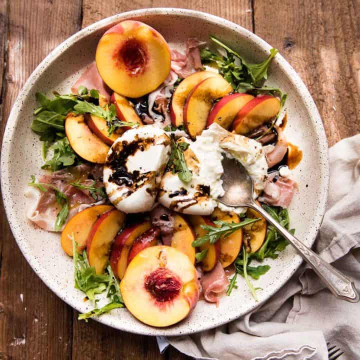 overhead photo of peach burrata salad in a large platter