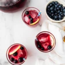 overhead photo of filled glasses and bowl of fruit