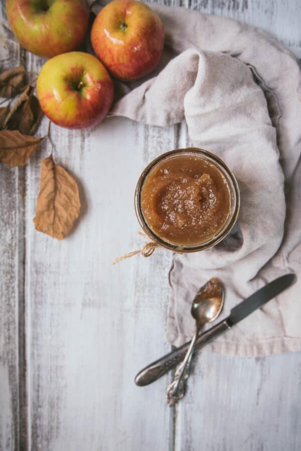 apples napkin and mason jar of apple butter on a white background