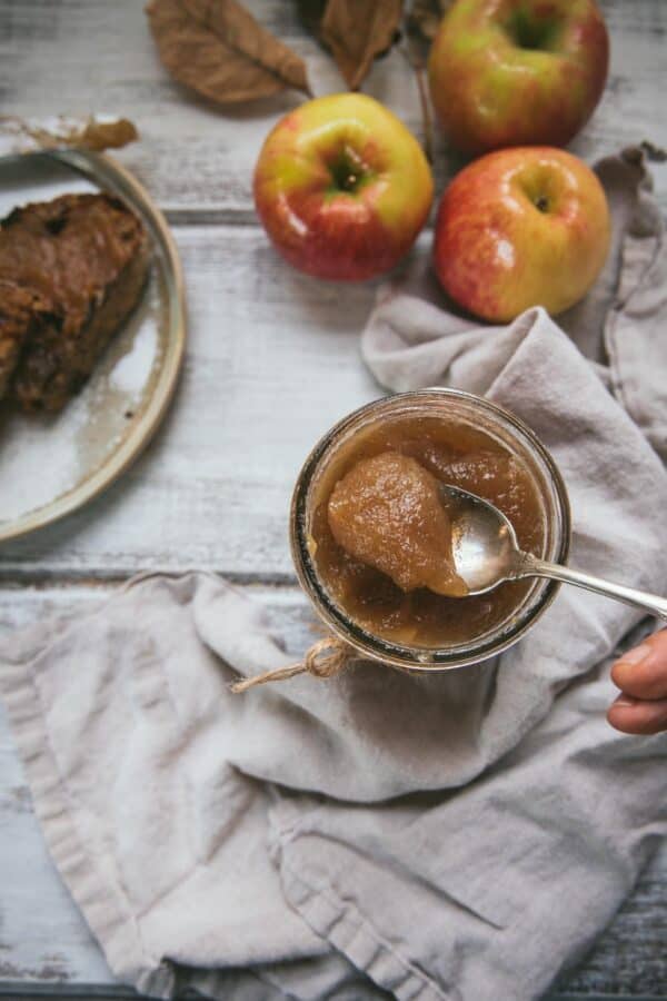 spoon scooping apple butter out of a mason jar