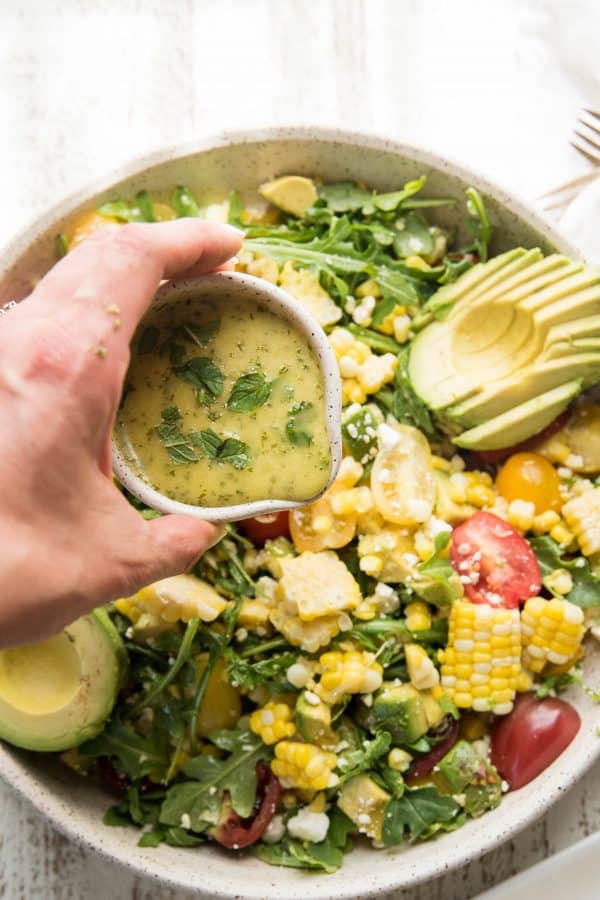 pouring dressing over salad