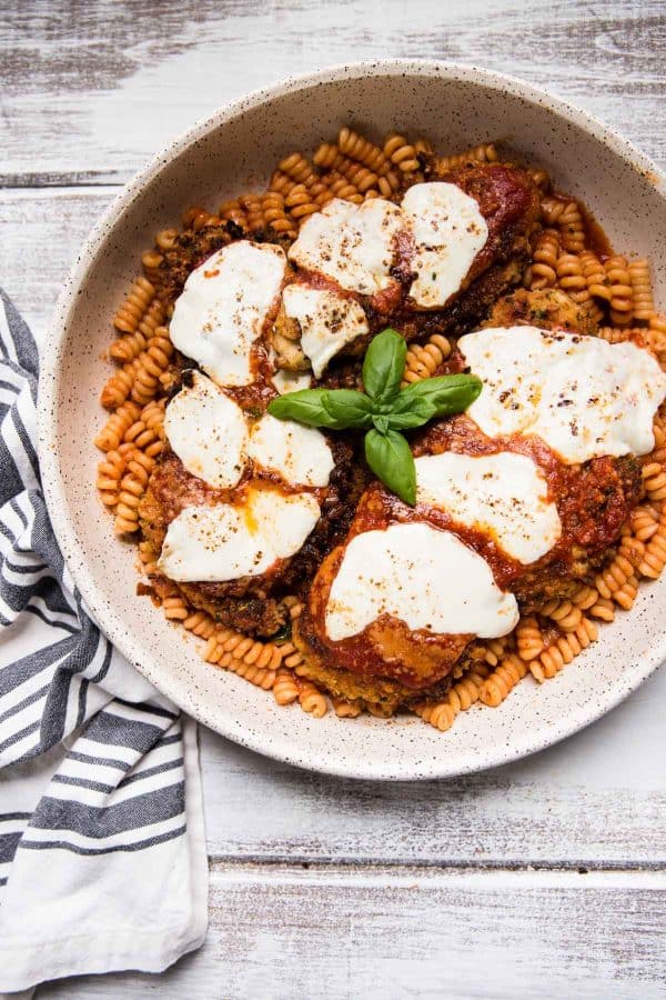 chicken parmesan over pasta on a platter