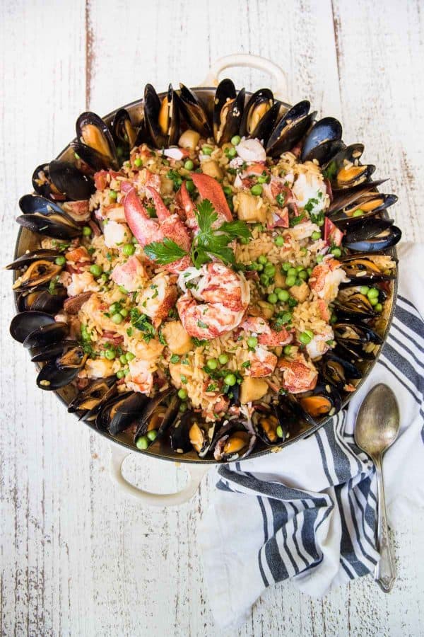 braiser pan with seafood paella surrounded by mussels