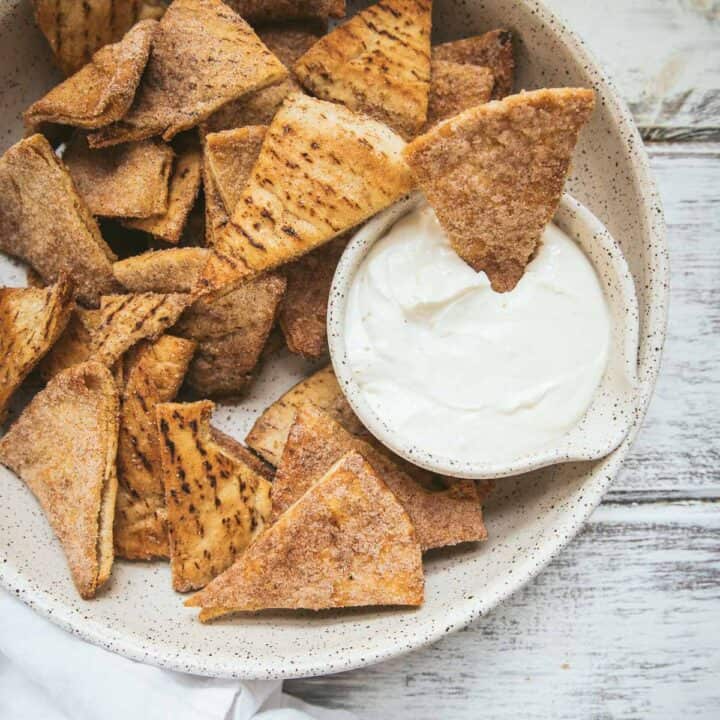 overhead angle of pumpkin spice pita chips in a serving bowl with dip