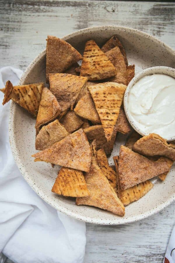 overhead angle of pumpkin spice pita chips in a serving bowl with dip