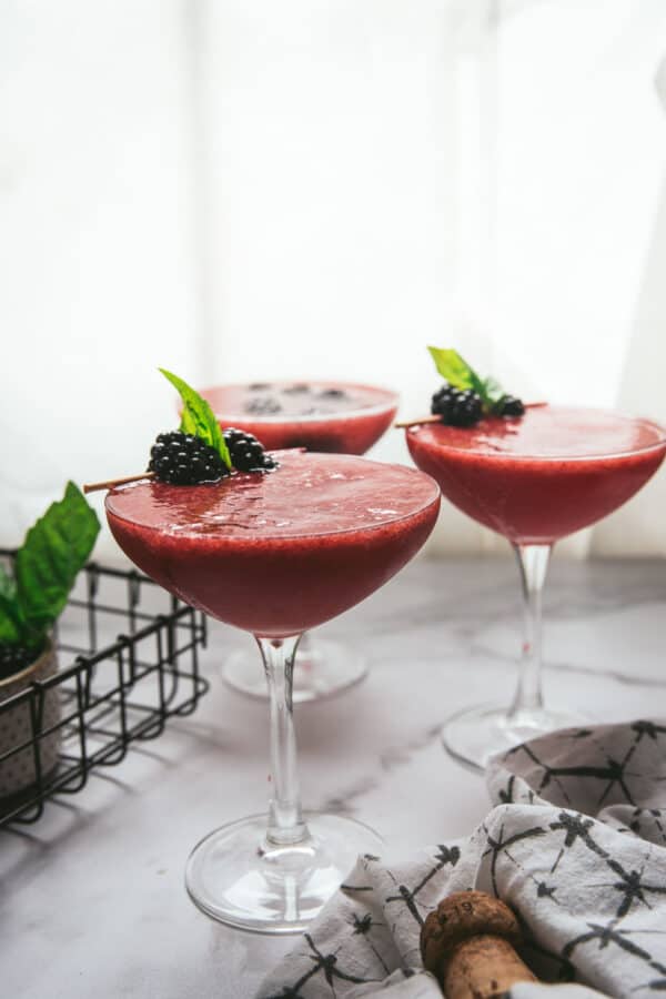 side angle of martinis with blackberry garnish