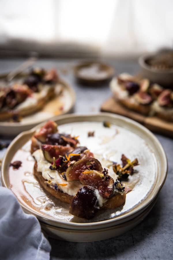 close up of ricotta on toast with roasted figs and honey