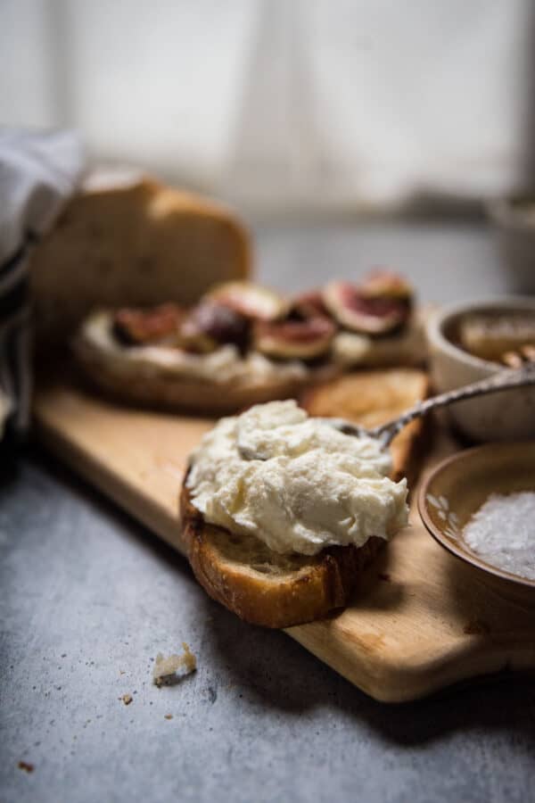 spreading whipped ricotta on toasted sourdough