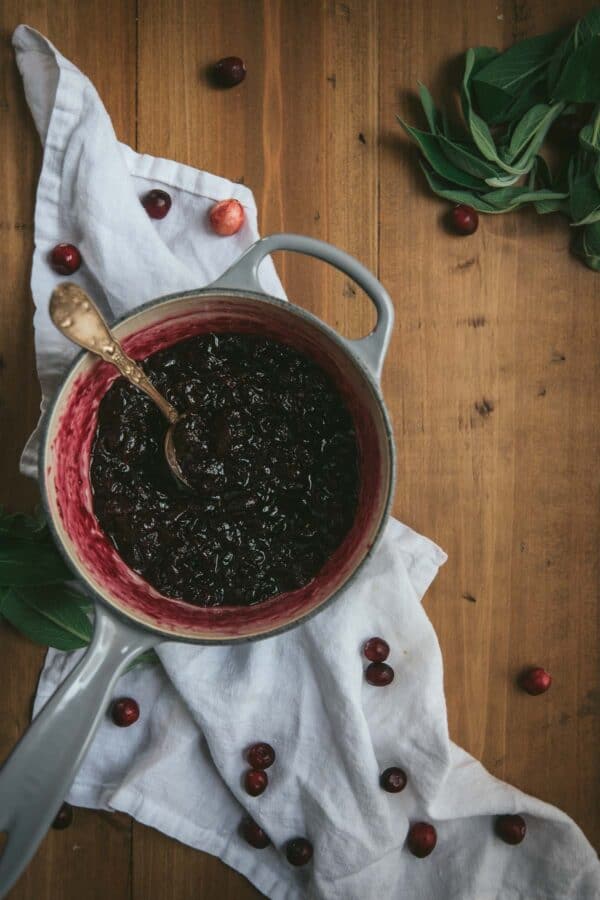 spoon in a saucepan filled with simmered cranberry sauce