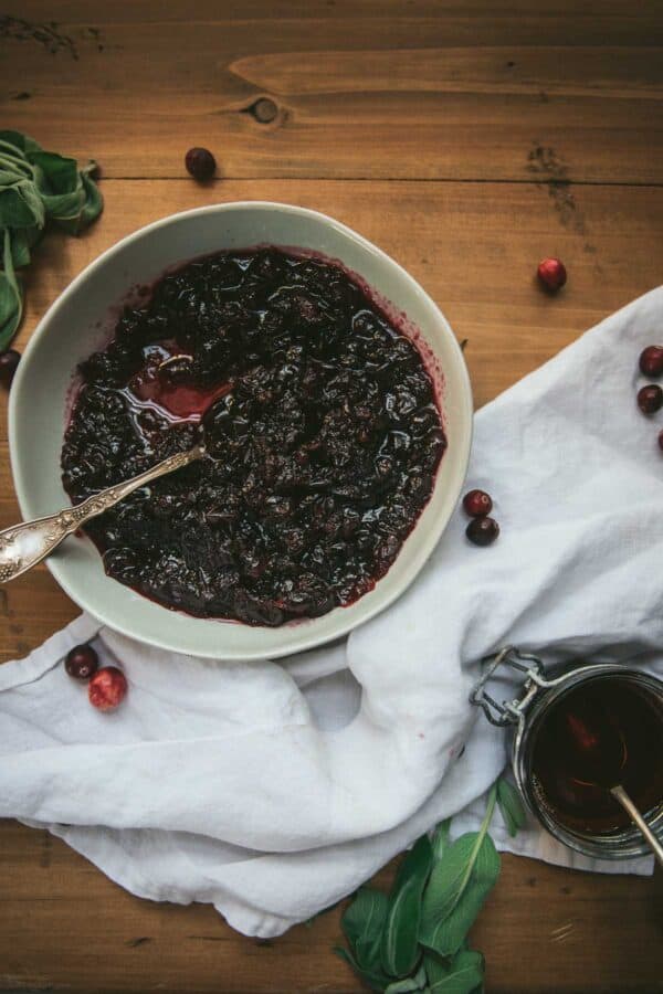 Homemade cranberry sauce in a mouth with white linen on table