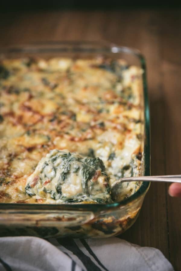 spoon scooping rainbow chard gratin out of baking dish