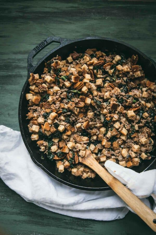 stuffing in a cast iron skillet with wooden spoon