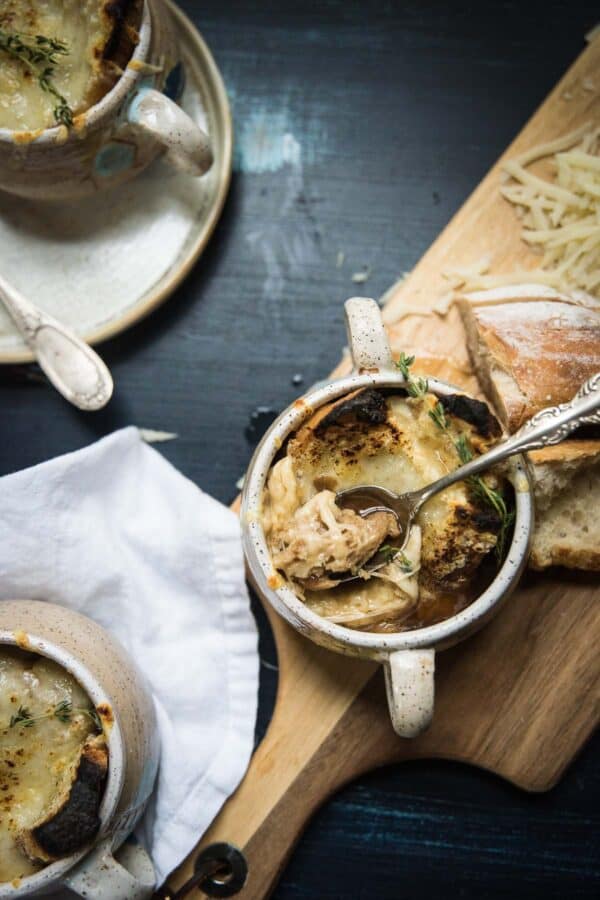 three bowls with soup covered in broiled cheese