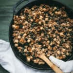 stuffing in a cast iron skillet with wooden spoon