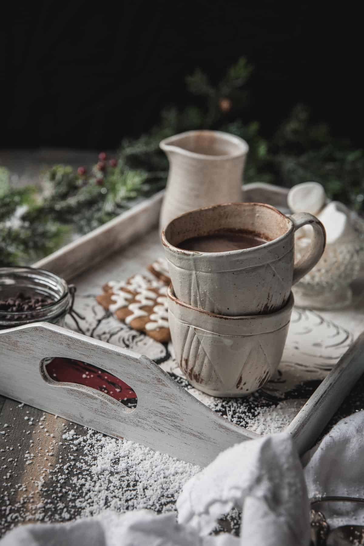 stacked cups of hot chocolate on a white serving tray