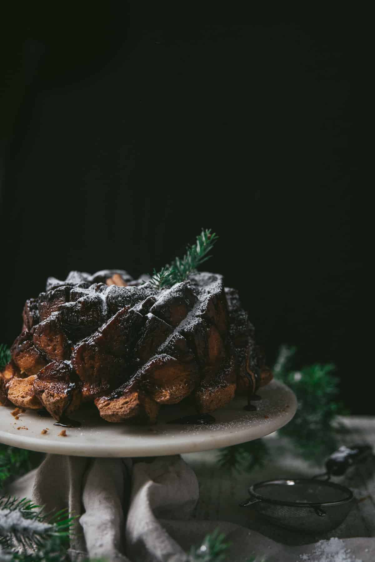 side angle of gingerbread monkey bread on a cake stand