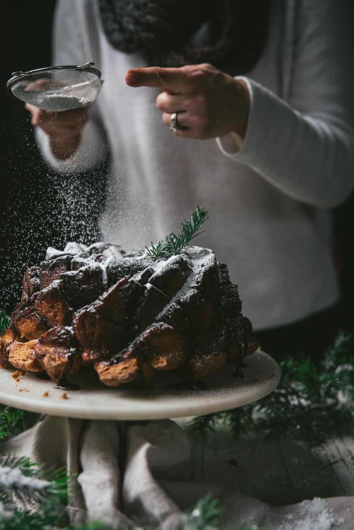 dusting powdered sugar over monkey bread