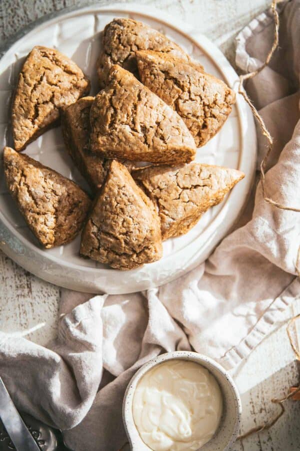 overhead view of scones on a platter with a bowl of icing on the side