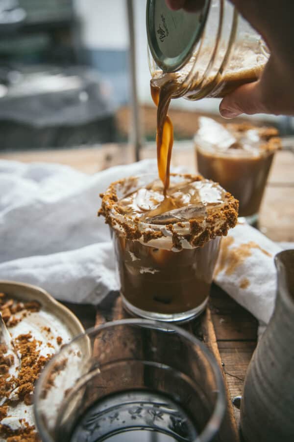 pouring drink into a glass over ice