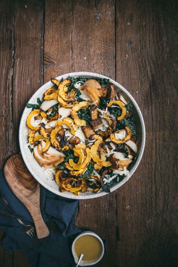 overhead of pear and cheddar kale salad with roasted squash