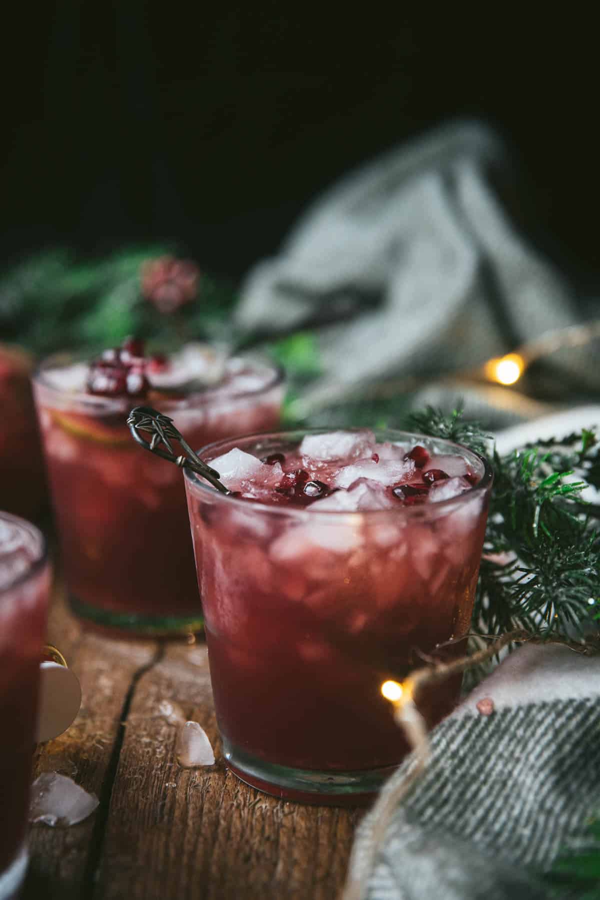 side angle of pomegranate cocktails on a wood background