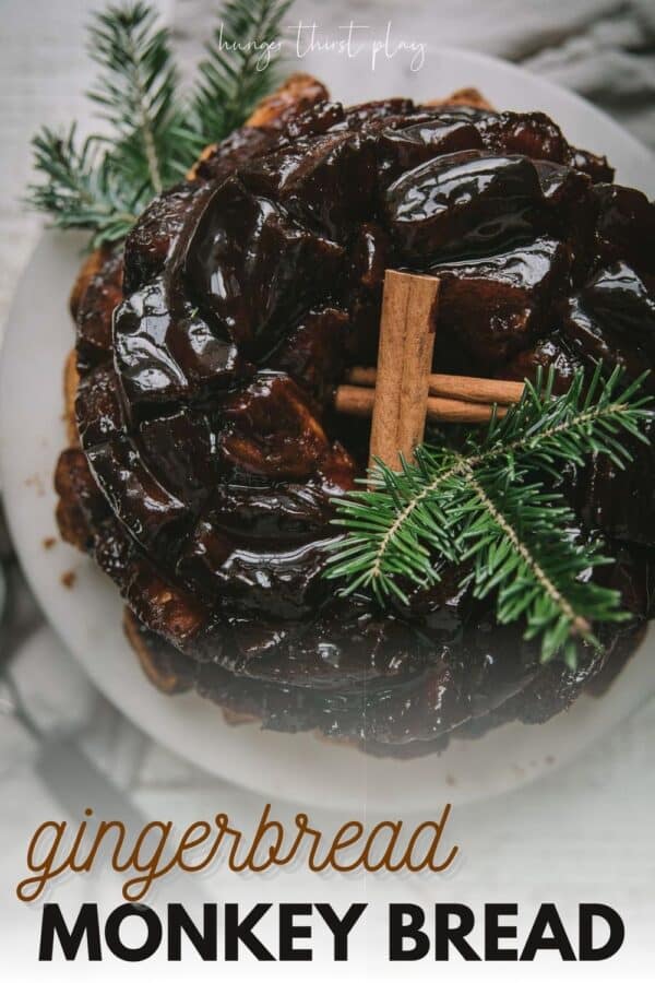 overhead of gooey monkey bread on a cake stand with cinnamon sticks and tree sprigs