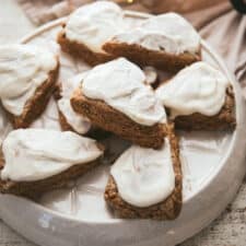 gingerbread scones with cream cheese frosting on a platter