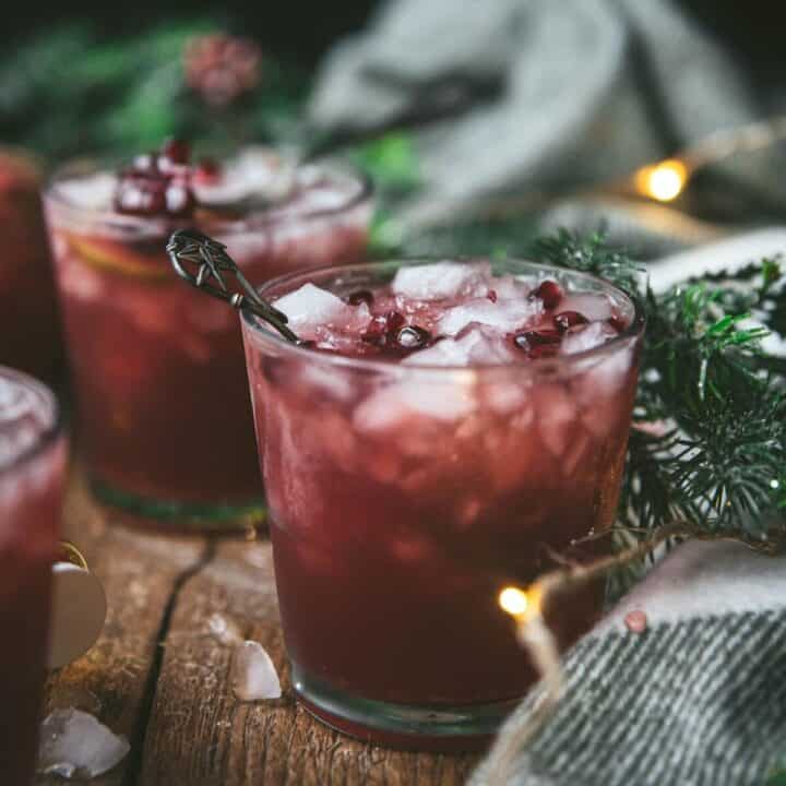 pomegranate cocktails and bottle of bourbon on wood background