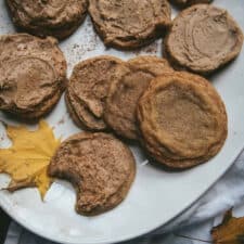 maple frosted cookies on a platter, one with a bite taken out of it